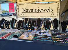 Jewelry display on a table with Navajojewels banner above